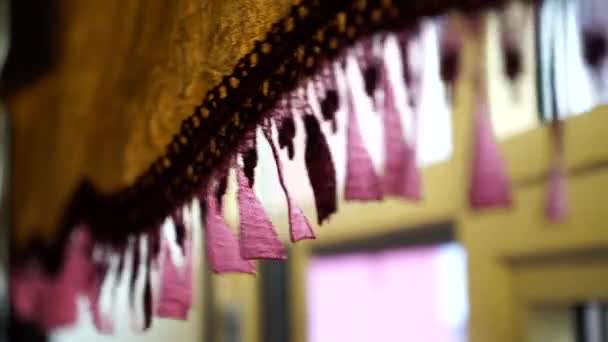Gros plan des rideaux de glands ondulés sur la fenêtre. L'ambiance de chaleur et de confort dans la maison 