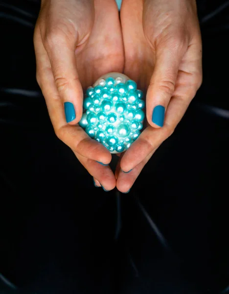 Female tattoos hands hold decorated Easter egg. The concept of turquoise color — Stock Photo, Image