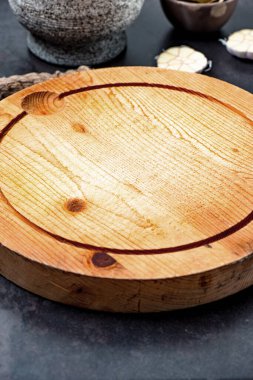 Taş havan topu kabuğu, sarımsak, defne yaprağı ve taş yüzeyde tahta kesme tahtası.