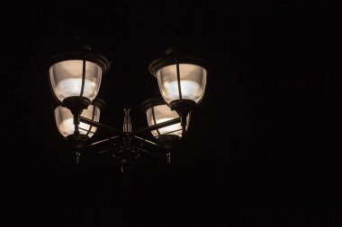 Sokak ışık gece arka planı. Bir kutup dört fenerler gece gökyüzünde parlayan. İçin tasarım, kolaj.