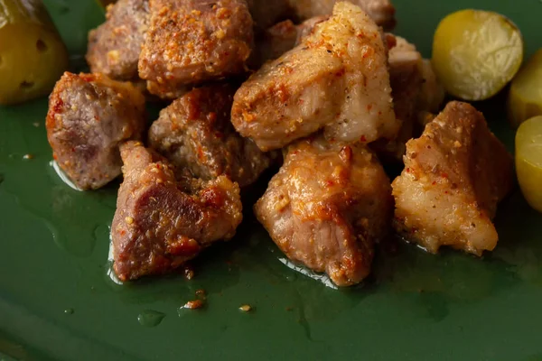 Stukken gebakken vlees op een groene schotel — Stockfoto