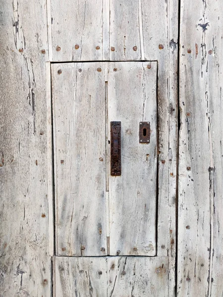 Parede rústica de madeira velha com porta pequena . — Fotografia de Stock