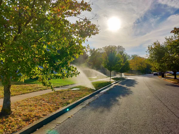 Aspersores de água na rua da cidade americana no dia ensolarado quente . — Fotografia de Stock