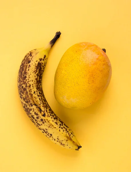 Überreife Banane Mit Dunklen Flecken Und Mangofrüchten Auf Gelbem Hintergrund — Stockfoto