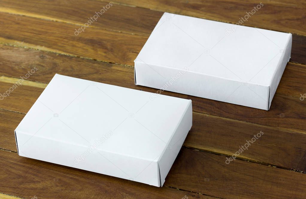 blank white cardboard package box mockup on dark wooden table