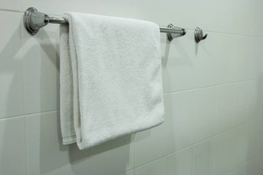 Banyoda asılı duran beyaz banyo havlusu. 