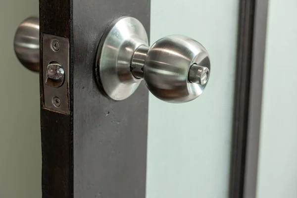 Roestvrij stalen deurknop met houten en mat glazen deur — Stockfoto