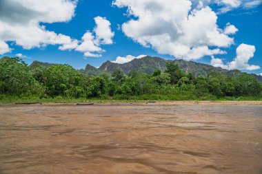 Amazon Nehri ve ormanı üzerinde sağanak yağış var. Fırtınanın ortasında suda yüzen küçük bir tekne var.
