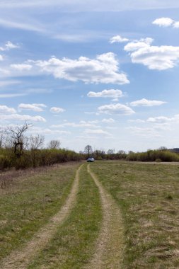 Baharda kırsal alan, mavi gökyüzünde yüzen bulutlar.