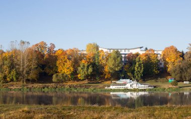 Nehirli sonbahar manzarası, berrak bir nehirde mavi gökyüzü yansıması.