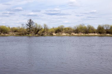 Nehir ve bulutlar durgun gökyüzünde süzülüyor