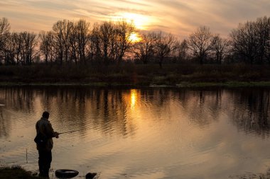 Nehrin üzerinde gün batımı, pembe gökyüzünün yansıması.