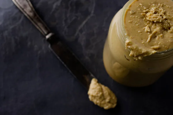 Nepořádná sklenice domácího arašídového másla — Stock fotografie