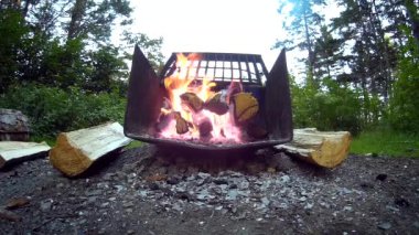 Bir kamp ateşi metal bir çukurda parlıyor ve çok fazla yakar 