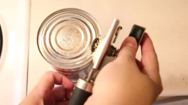  Bir el el ile konserve açacağı tutar ve gümüş bir metal kutu açılır 