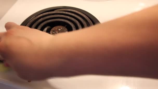 一只手拿着一只绿色黄色的海绵 把炉子顶部的西红柿污渍擦掉 — 图库视频影像