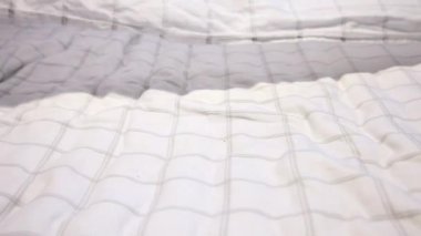 Beyaz sayfaları gri çizgili atılmış ve attı, kayan aşağı bir yatak üzerine