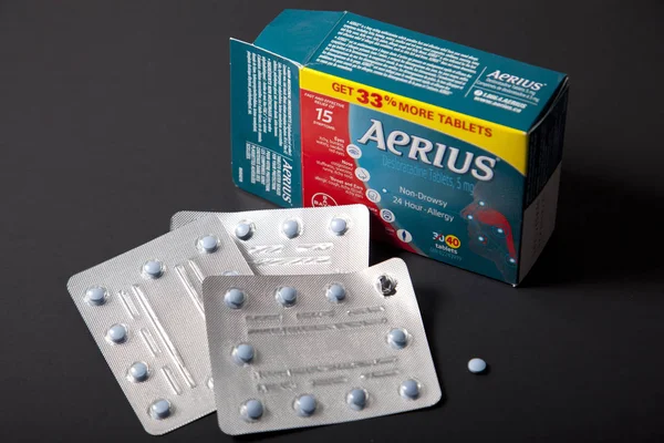 Package of Aerius allergy medicine and single tablet on a black — Stock Photo, Image