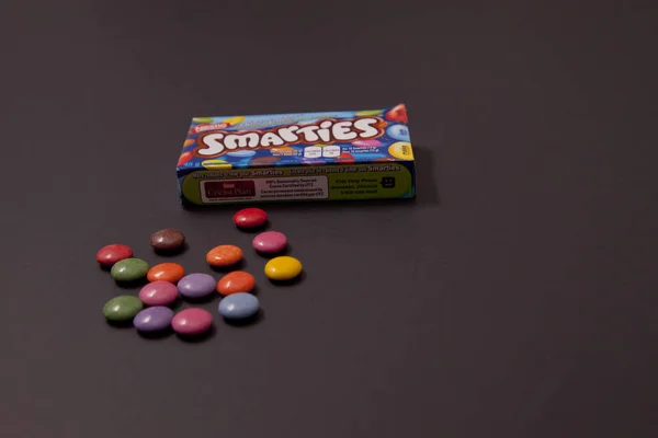 Small different coloured Smarties next to box — Stock Photo, Image