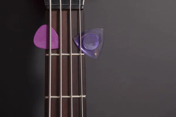 Bass guitar neck with two purple picks