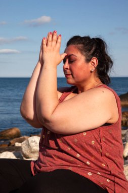 Dışarıda meditasyon yapan kişi ellerini üçüncü gözüne koyar.