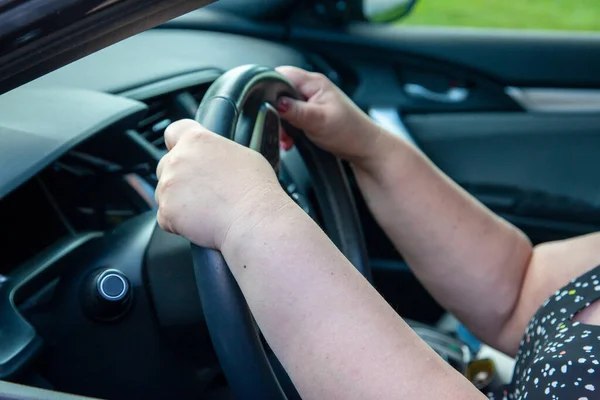 stock image person's hands at the 10 and 2 position on the steering wheel while driving a car 