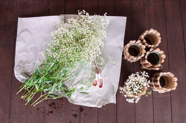 Hand-made details in the creation process, beautiful wooden glasses and a branch of white flowers