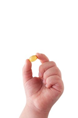 Omega 3 kapsül beyaz arka planda tutan çocuğun el. Yakın çekim. Yüksek çözünürlüklü ürün. Sağlık kavramı.