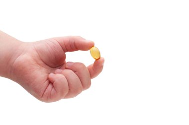 Omega 3 kapsül beyaz arka planda tutan çocuğun el. Yakın çekim. Yüksek çözünürlüklü ürün. Sağlık kavramı.