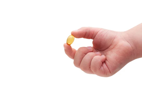Omega 3 kapsül beyaz arka planda tutan çocuğun el. Yakın çekim. Yüksek çözünürlüklü ürün. Sağlık kavramı.