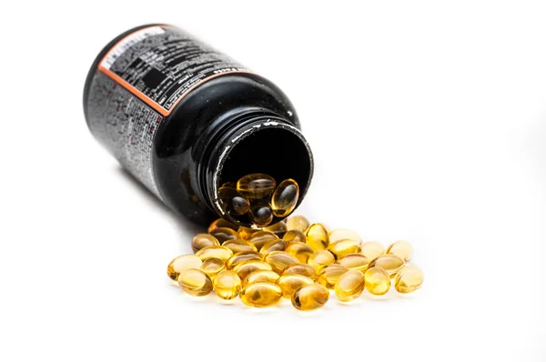 Omega 3 fish oil capsules spilled from a plastic bottle on a white background. Medical food supplements. Unsaturated fatty acid. Health care concept.