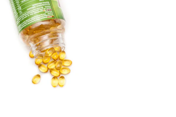 Omega 3 fish oil capsules spilled from a plastic bottle on a white background. Medical food supplements. Unsaturated fatty acid. Health care concept.
