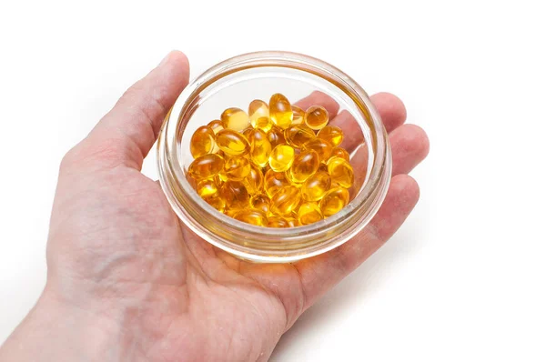 Erkek el Beyaz arka plan üzerinde izole Omega 3 kapsülleri tutuyor. Sağlık ve uzun ömür kavramı.