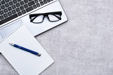 Ofis aksesuarları ile üst görünüm Office masaüstü, dizüstü bilgisayar ve gözlük ile Masaüstü ve kalemli not. Tasarımınız veya yüklemeniz için boş alan içerir. İş ve iş kavramı.