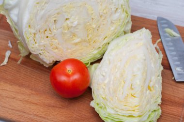 Ahşap masa üzerinde kesilmiş lahana ve domates ile kompozisyon. Sağlıklı organik beslenme konsepti.