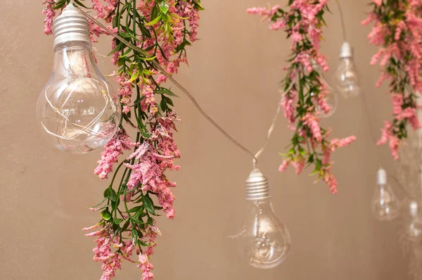 Close up view of vintage decorative light lamp bulb glowing on the ceiling indoors. Transparent lamps glowing with warm light.