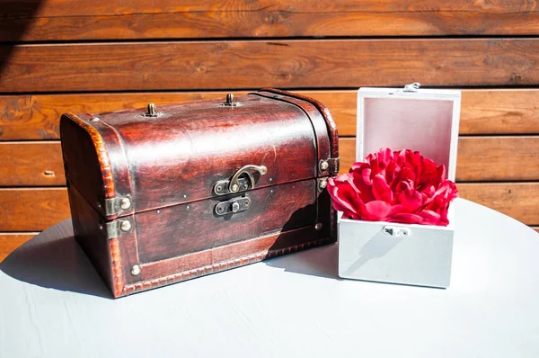 Antique box and a beautiful bouquet on a wooden background.