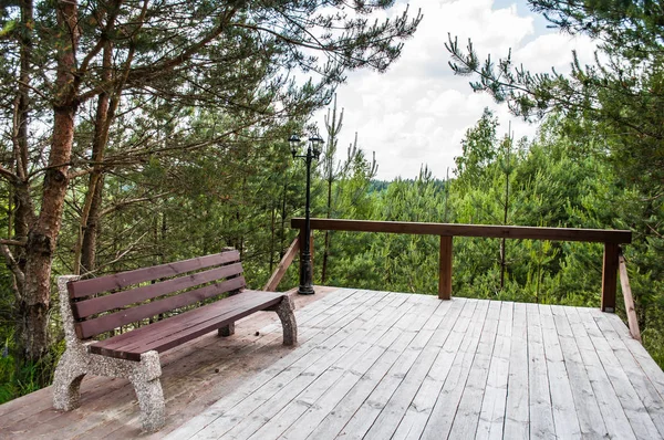 A park bench on the terrace on a summer day. The concept of recreation and ecology.