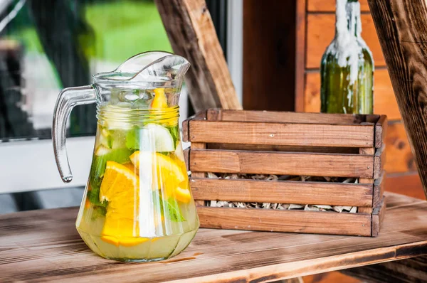 Sıcak bir yaz gününde terasta ev yapımı serinletici buzlu narenciye limonata bir sürahi. Detoks diyeti kavramı.