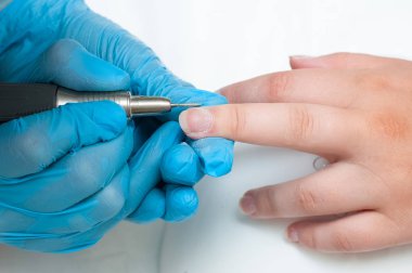 Kadın güzellik salonunda elektrikli tırnak dosyası matkap kullanın. Mükemmel çivi manikür işlemi veya yakın çekimde çalışma.