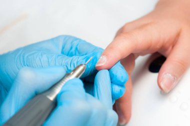 Kadın güzellik salonunda elektrikli tırnak dosyası matkap kullanın. Mükemmel çivi manikür işlemi veya yakın çekimde çalışma.