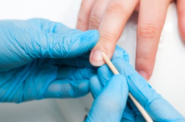 Manikürcü masada müşterinin tırnakları ile çalışan, closeup.