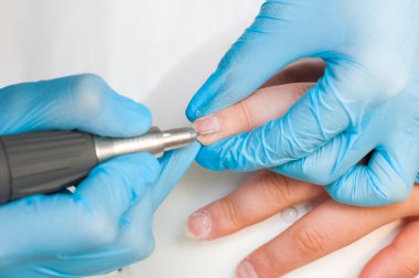 Kadın güzellik salonunda elektrikli tırnak dosyası matkap kullanın. Mükemmel çivi manikür işlemi veya yakın çekimde çalışma.