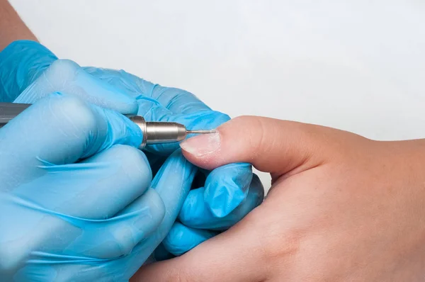 Kadın güzellik salonunda elektrikli tırnak dosyası matkap kullanın. Mükemmel çivi manikür işlemi veya yakın çekimde çalışma.