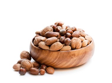 Ahşap kase üzerinde beyaz izole içinde çeşitli fındık 