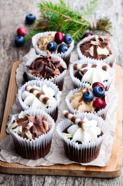Ahşap masa üzerinde Noel dekorasyonu ile Çikolatalı mini kekler 
