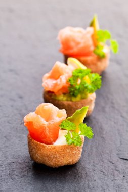 Tuzlanmış somon ve avokado siyah taş zemin üzerine croustades gevrek pasta durumlarda dolu 