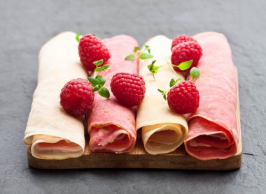 Haddelenmiş süt ve siyah taş zemin üzerine ahududu krep 