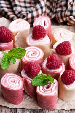 Haddelenmiş süt ve ahududu krep yerken üzerine ahşap masa 