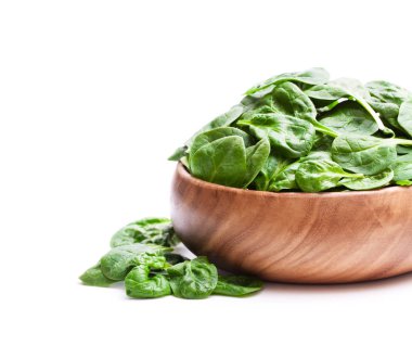 Beyaz arka planda izole edilmiş ahşap kasede ıspanak yaprakları. 